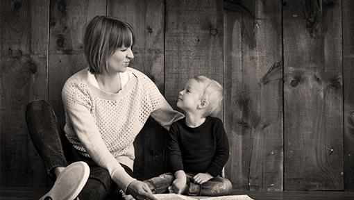 Mum laughing with her young son in their home