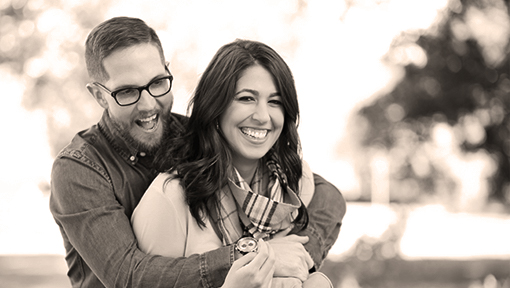 Happy couple laughing outside their home