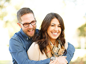 Happy couple standing in front of their home